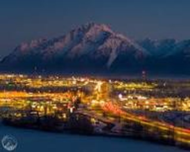 Palmer, Alaska lights at night beneath snowy Pioneer Peak